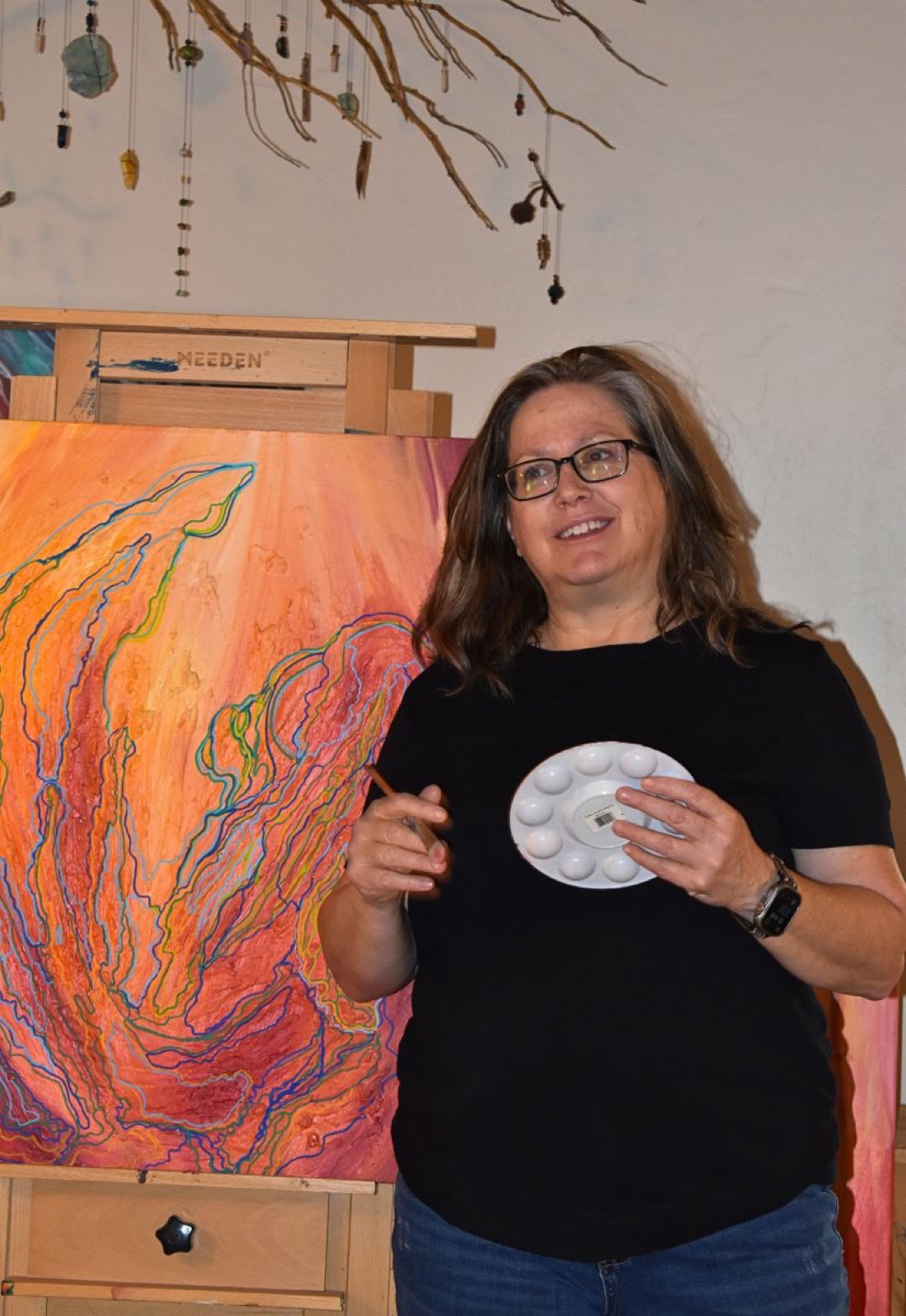 Diane Crenshaw standing beside her easel in her home studio
